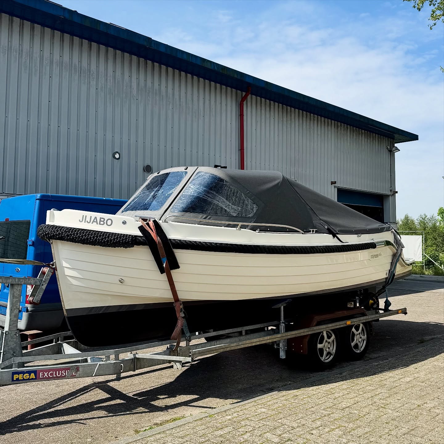 Witte sloep Jijabo met zwarte buiskap, aangemeten op de boot
